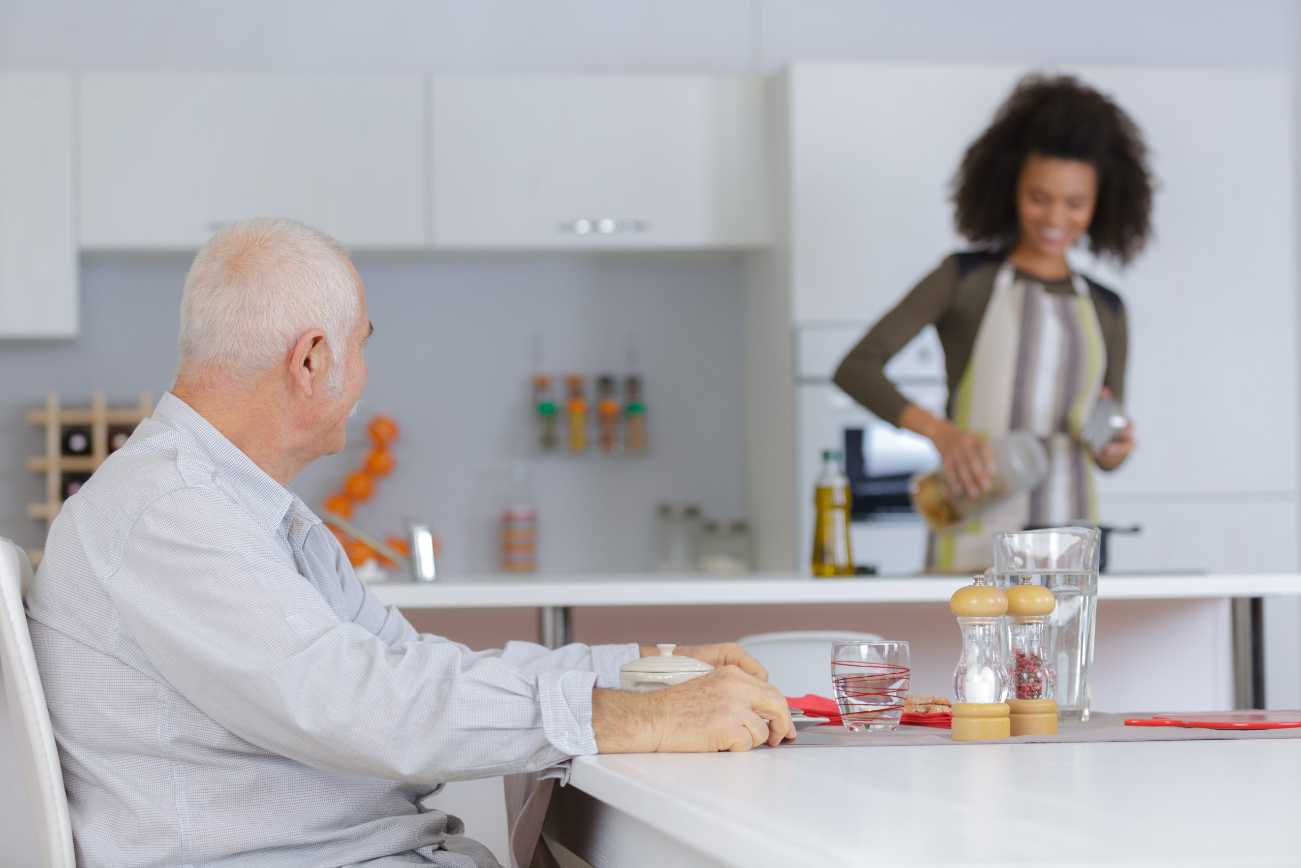 young female caregiver preparing food for her employer