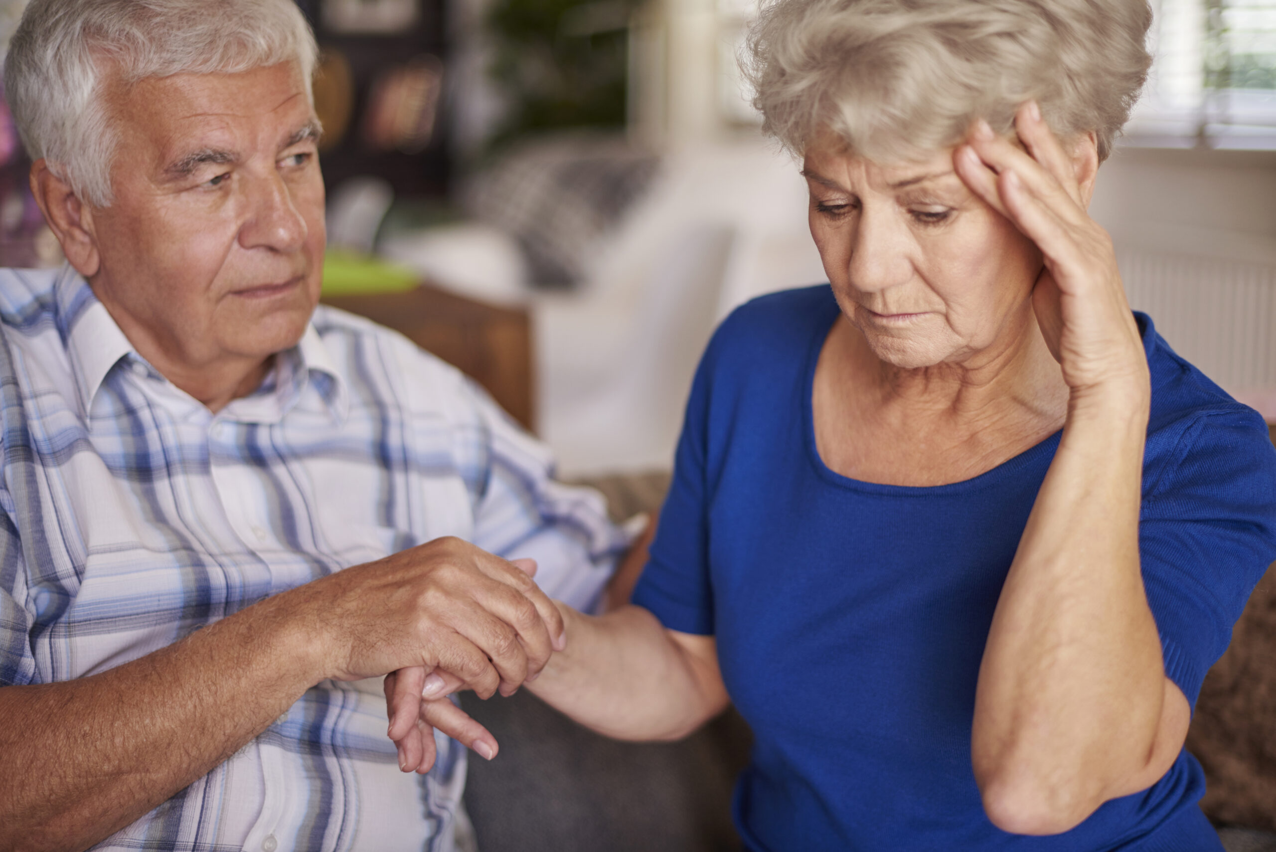 senior couple getting a tablet video phone call from their family